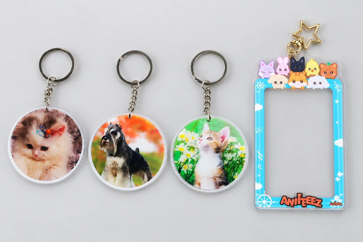 Three round acrylic pet photo keychains beside a blue animal-decorated acrylic photo-frame charm with a gold star clasp.