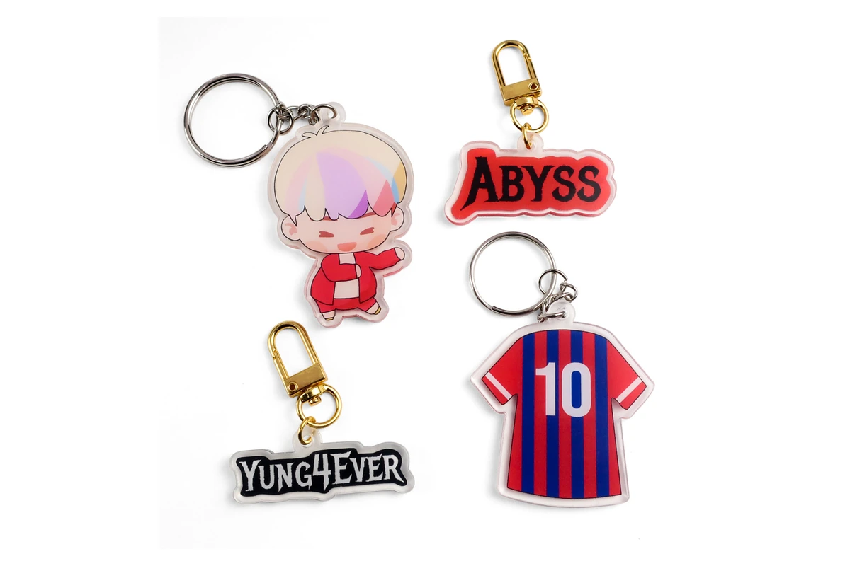 Clear acrylic keychains with character, lettering, and soccer jersey designs.