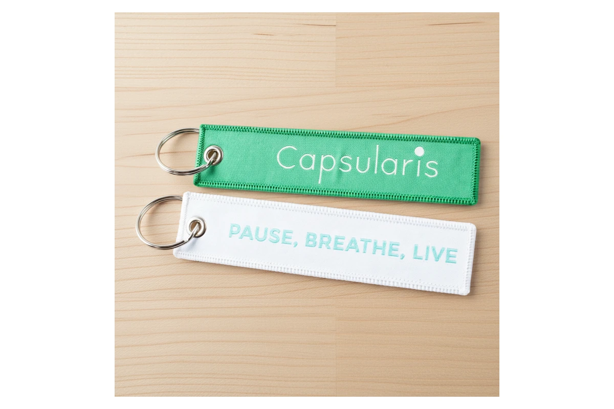 Fine lettering, fabric texture and stitched edges on two textile key tags