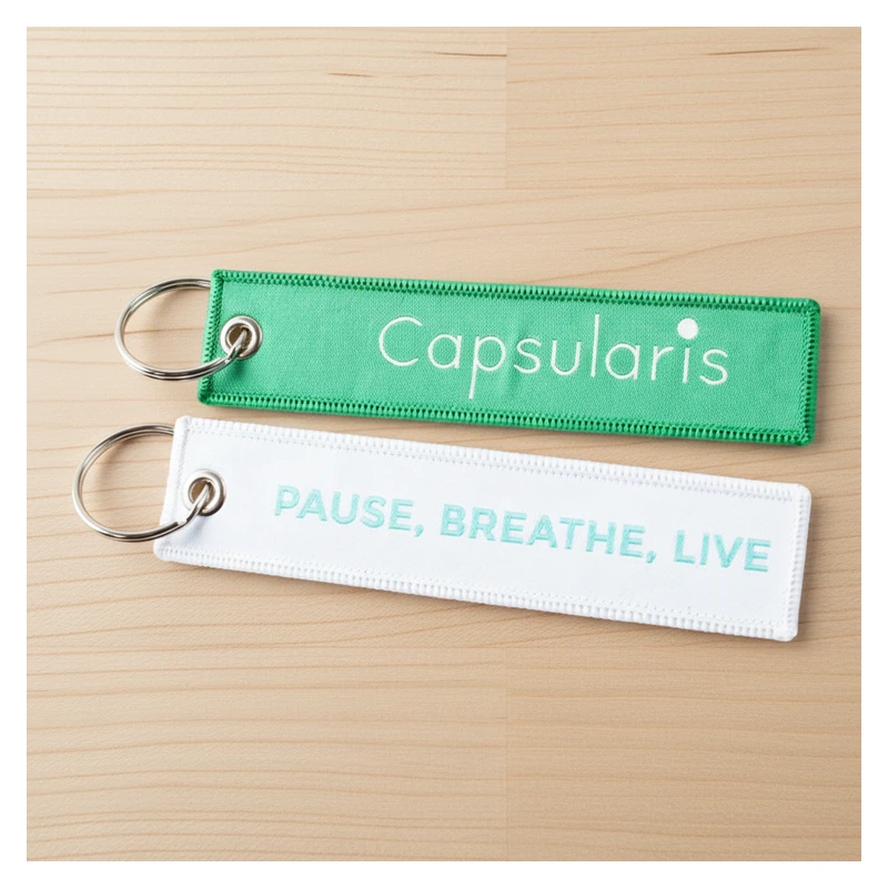 Green and white woven fabric key tags with fine lettering