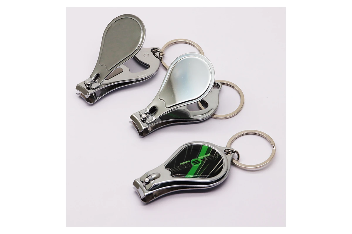 Nail clipper levers and bottle opener openings on compact metal keychains
