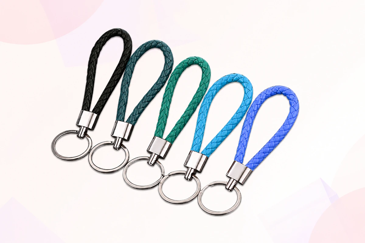 Five braided loop keychains in black, teal, green and blue with metal fittings.