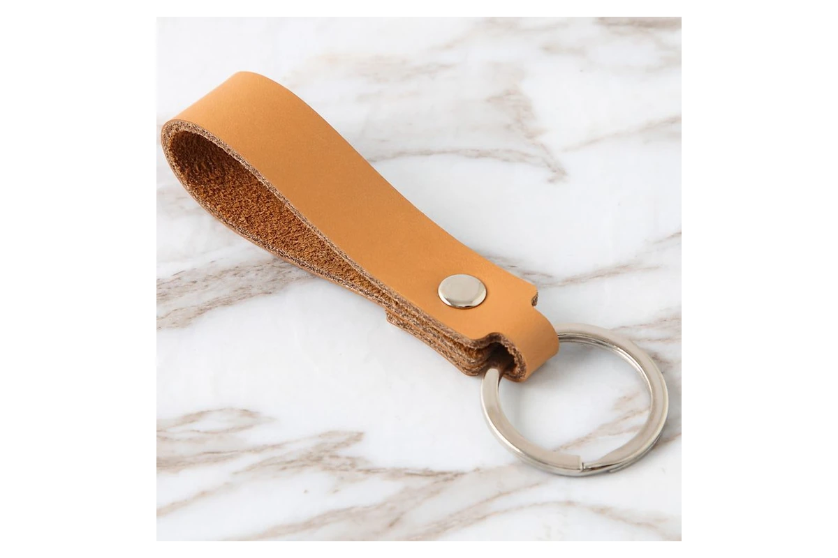 Tan leather loop showing its cut edges, metal rivet and split ring.