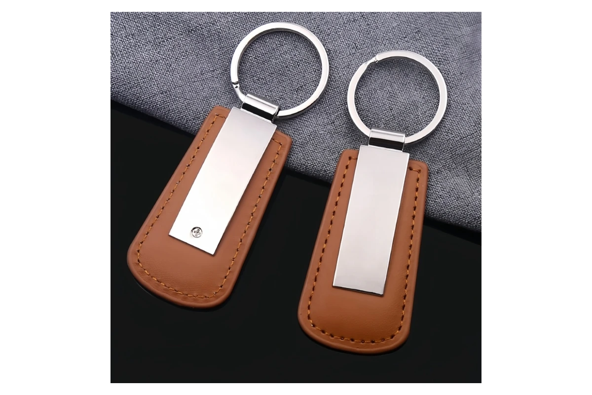 Brown stitched leather key tags fitted with long silver-tone metal plates.