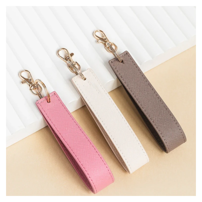 Pink, cream and taupe leather wristlet straps with gold-tone clips and rings.