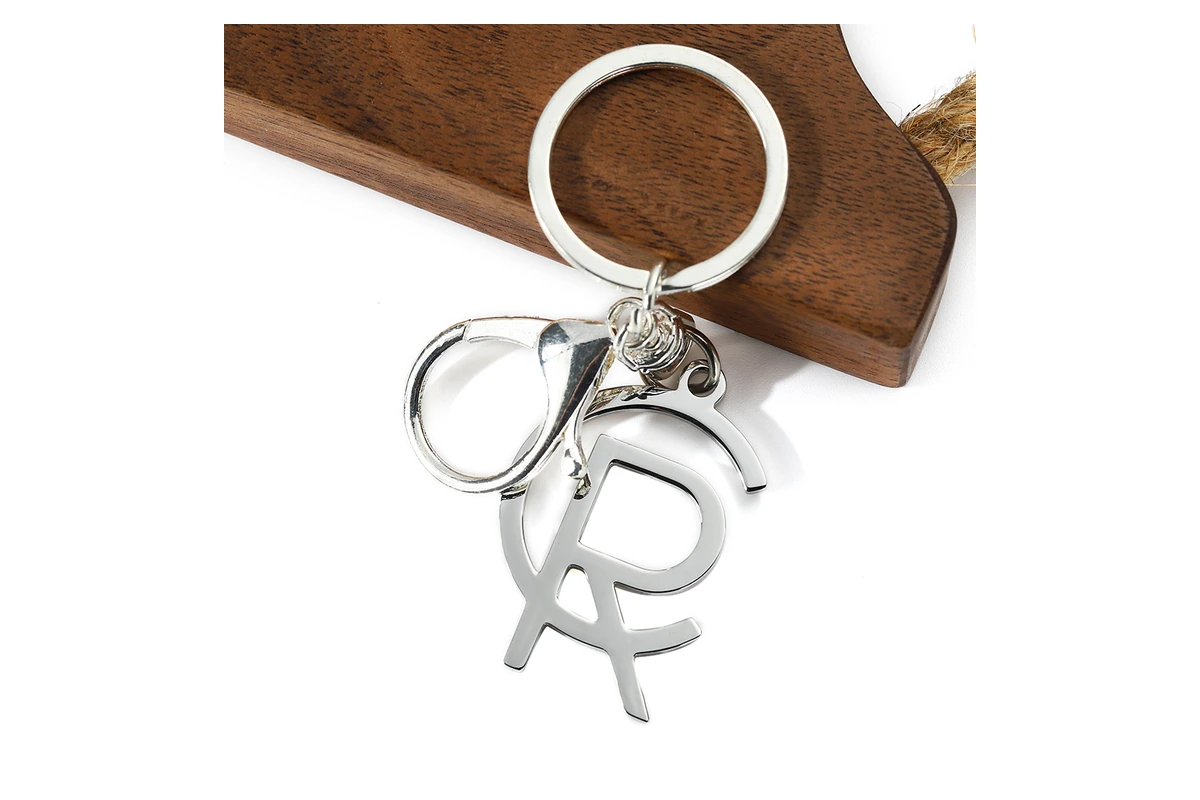 Silver-tone keychain with an open, interlocking letter design.