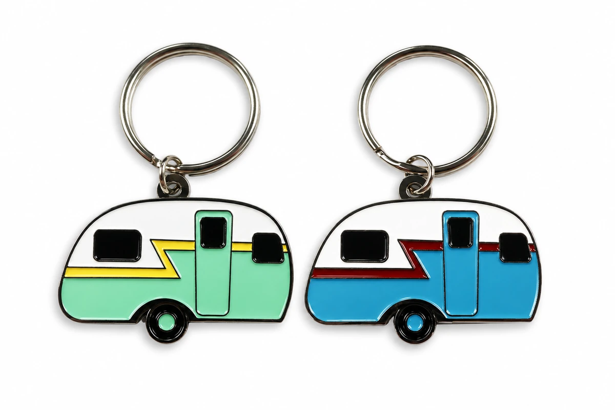 Two camper trailer-shaped metal keychains in green and blue with split rings.