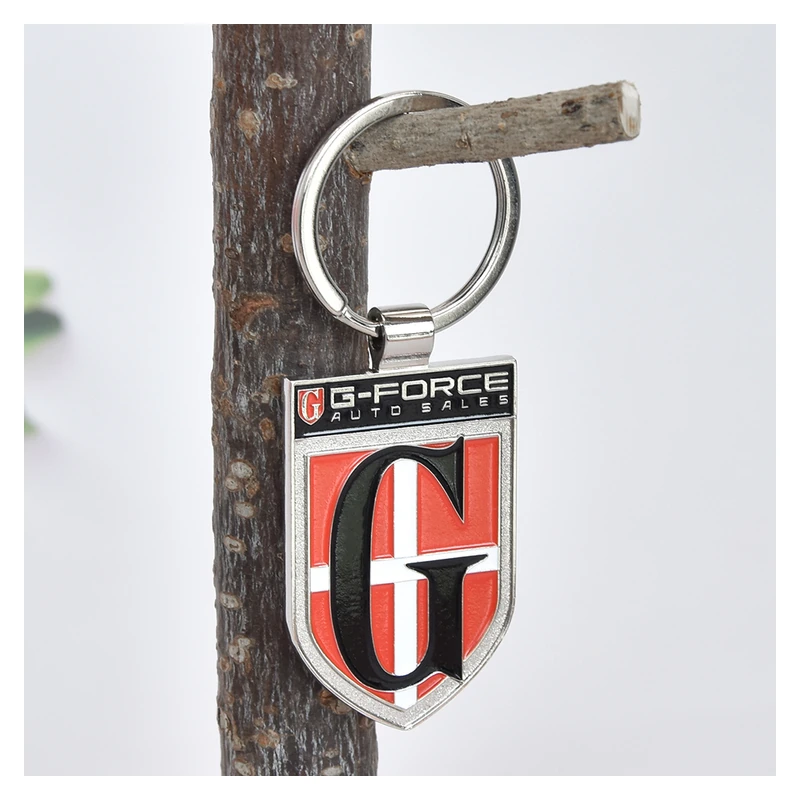 Shield-shaped metal keychain with red and black color fills and raised silver-tone outlines.