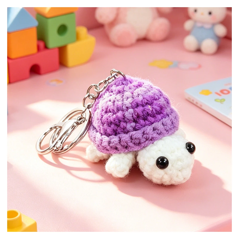 White crochet turtle keychain with a purple shell and metal ring