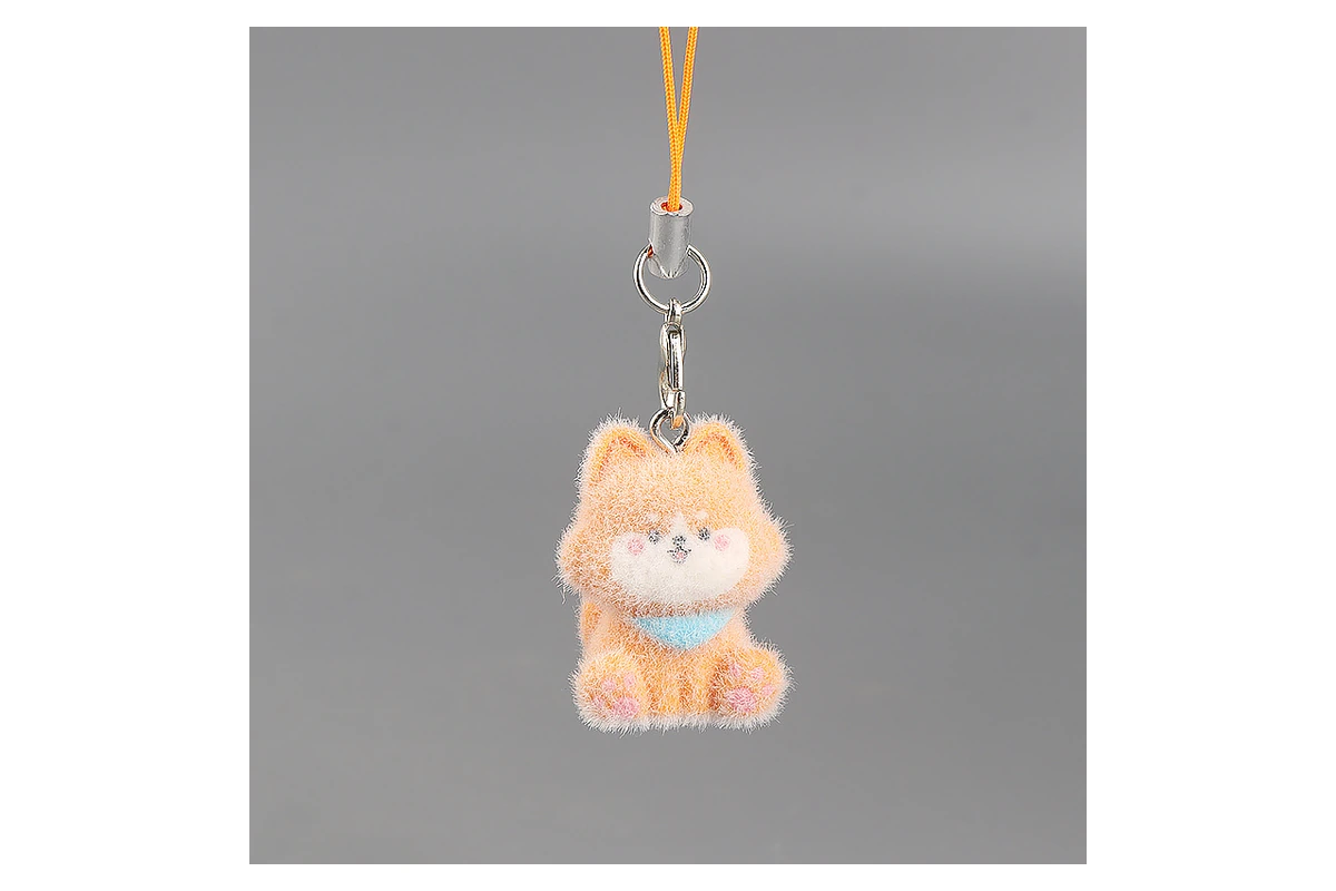 Metal clasp and cord above an orange miniature plush cat