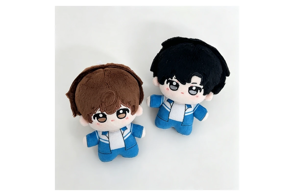 Two shaped plush dolls with embroidered faces and small arms and legs