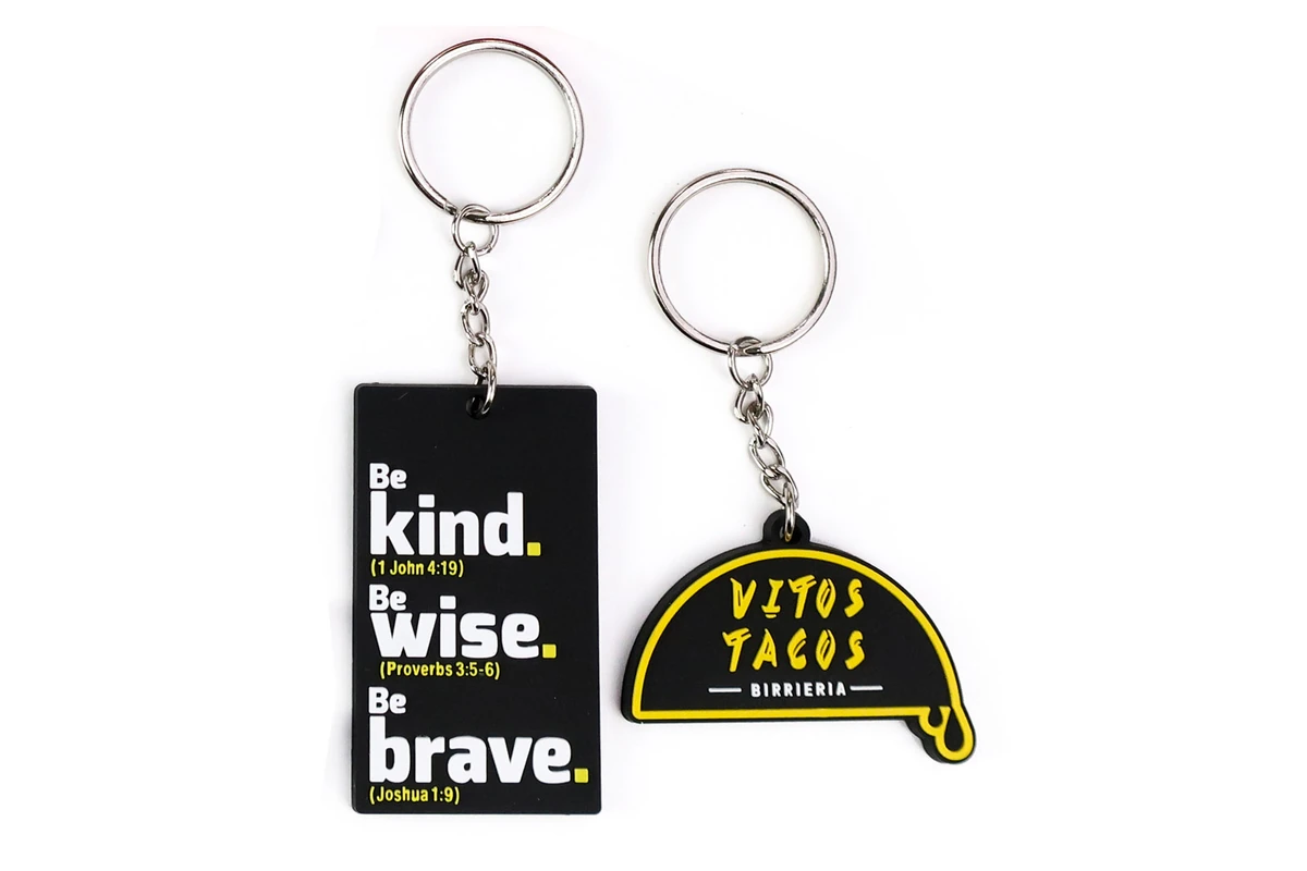 Black PVC keychains with contrasting yellow and white lettering.