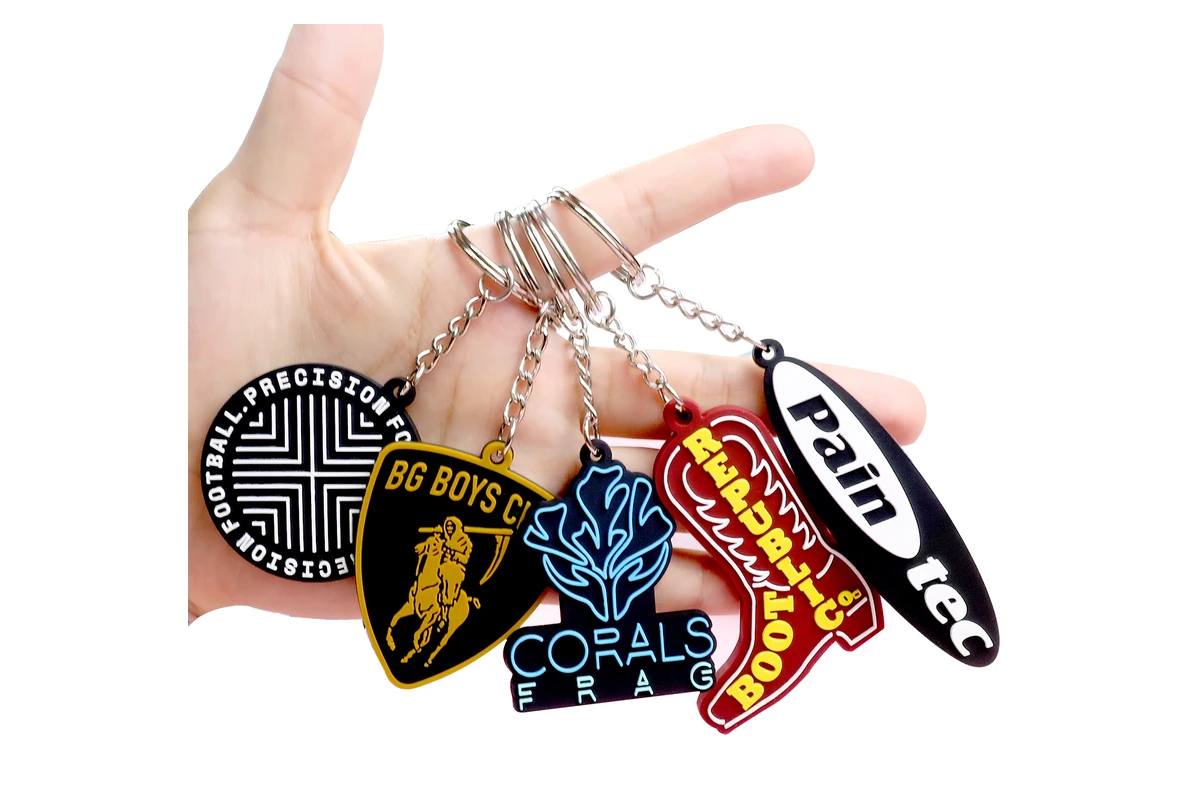Assorted colorful logo keychains hanging from metal chains.