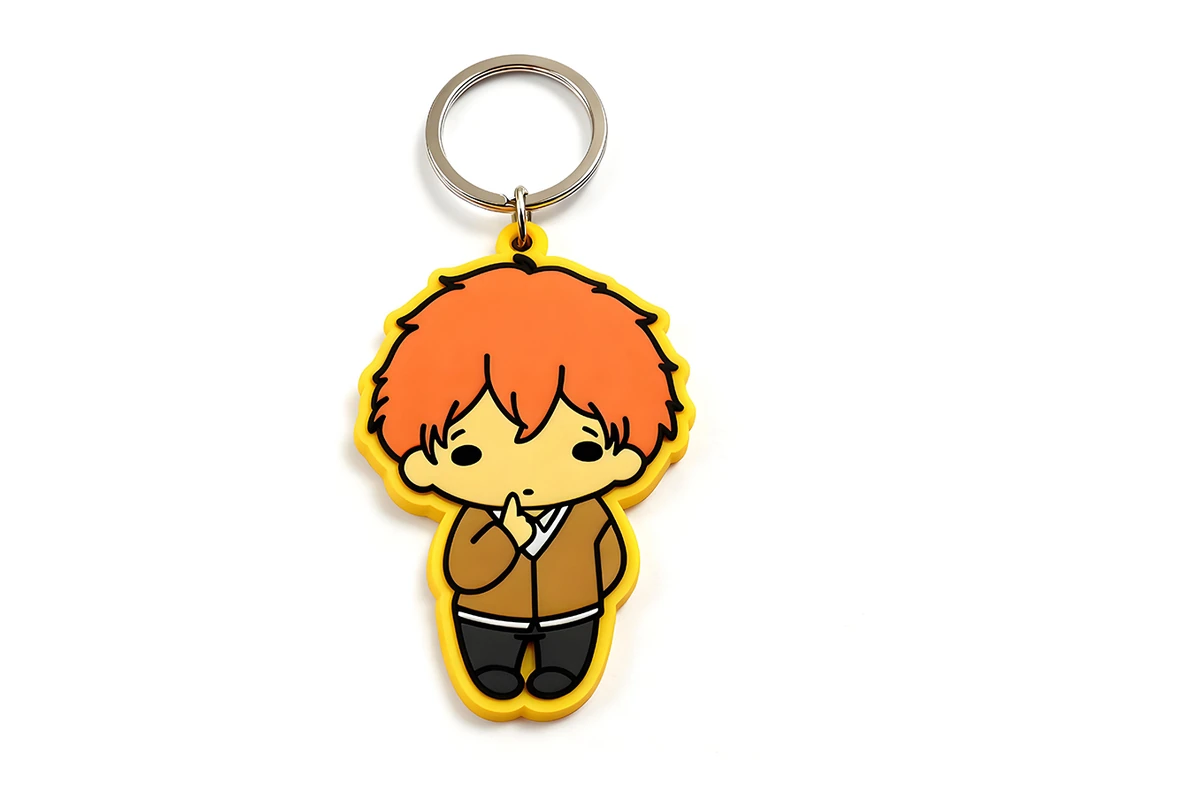 Yellow-edged PVC character keychain with orange hair.