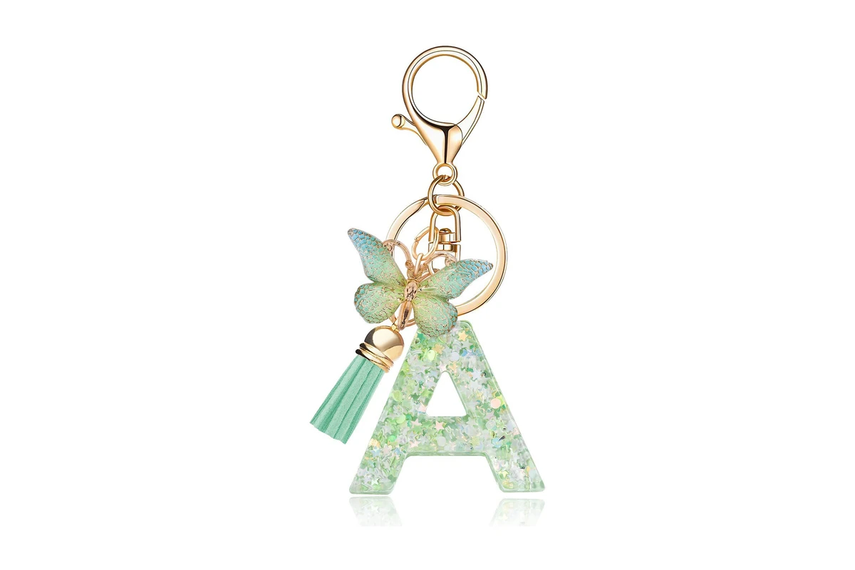 Clear green letter A charm with embedded confetti, a butterfly, and a tassel.