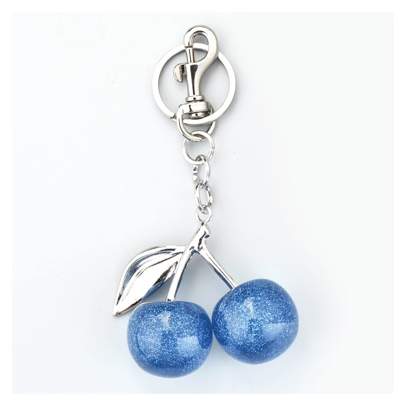 Blue glitter cherry keychain with a silver-colored clasp and leaf.
