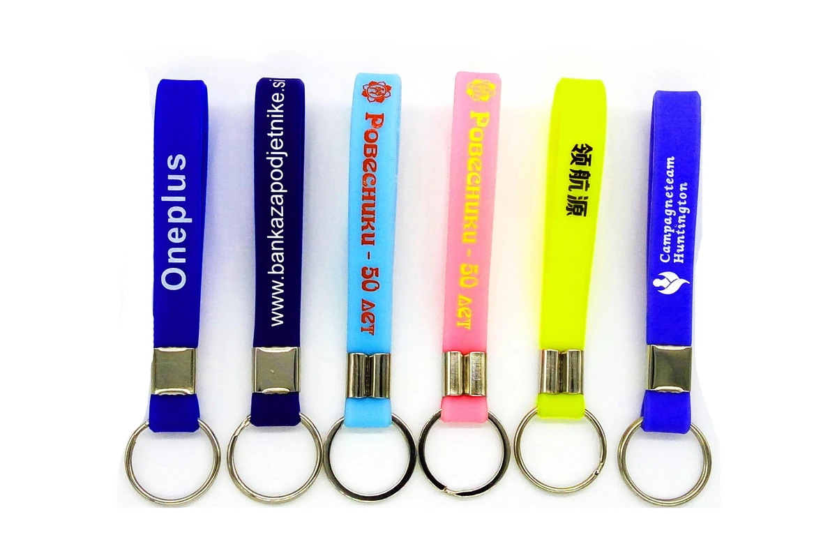 Silicone wristlet keychains in several colors with printed brand lettering.