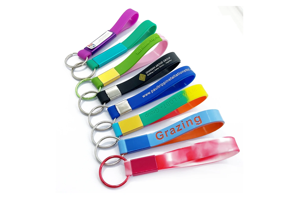 Colorful silicone wristlet keychains with printed lettering and metal rings.