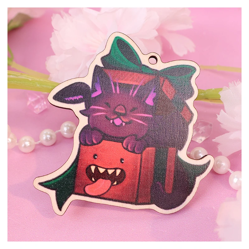 Printed wooden cat charm with a shaped edge and attachment hole.