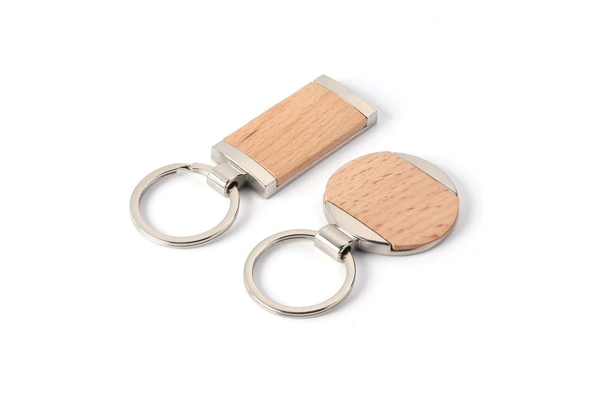 Round and rectangular wooden keychains with visible grain and silver-tone metal fittings.