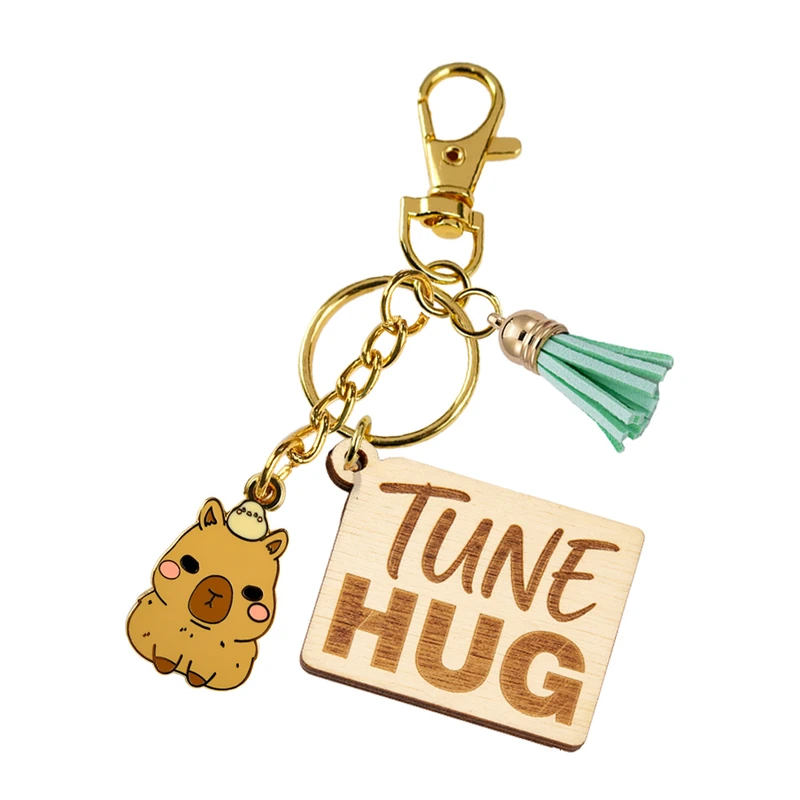 Engraved wooden tag with a green tassel, animal charm and gold-tone clip.
