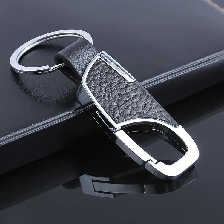 Close-up of a black textured keychain insert with silver-tone trim and an oval clip.