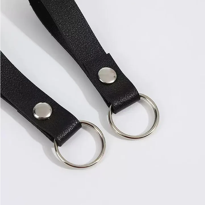 Close-up of black key fob straps with textured surfaces, silver-tone rivets, and split rings.