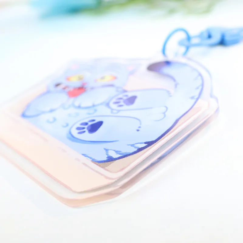 Low-angle close-up of a blue cartoon cat charm showing its clear edge and pale pink border.