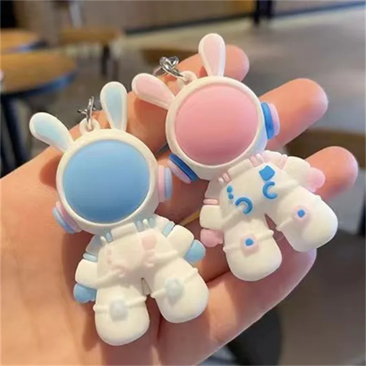 White bunny astronaut keychains with blue and pink helmet visors.