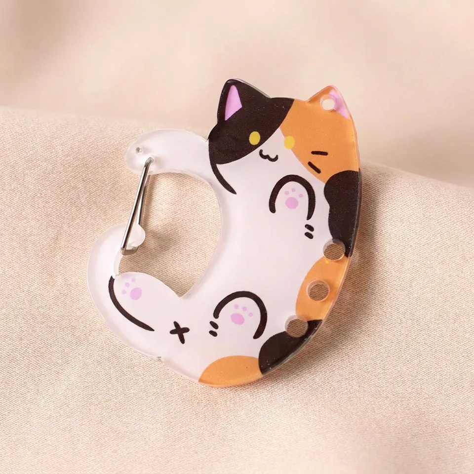 White, orange, and black calico cat clip with pink paw details and a silver-tone spring gate.