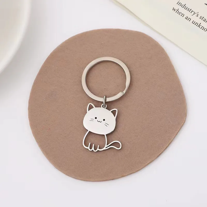 Silver-tone cat outline keychain with a round face and curved tail.