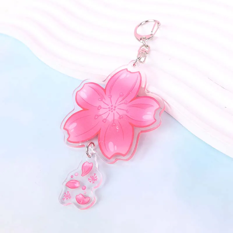 Pink cherry blossom keychain with a small clear petal charm.