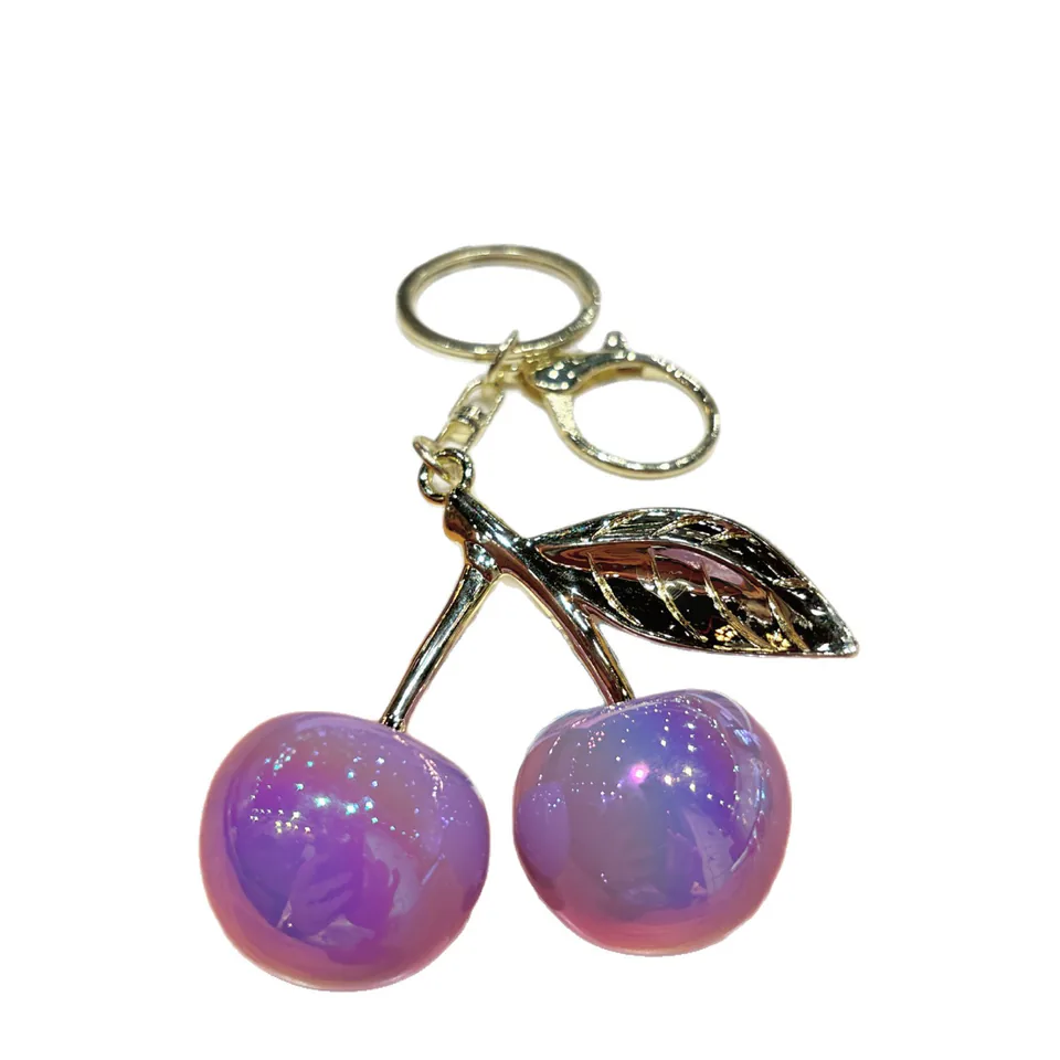 Purple cherry-pair keychain with iridescent fruit charms and a gold-tone leaf.