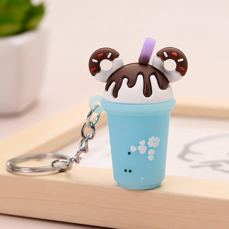 Blue drink-cup keychain with brown drizzle, donut decorations, and a purple straw.