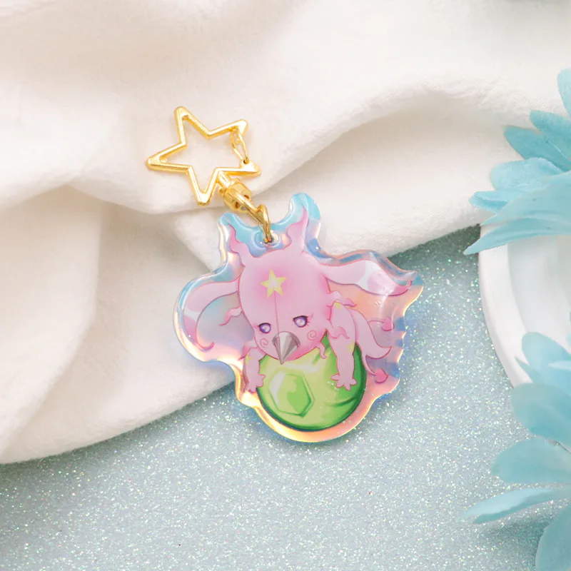 Angled view of a pink dragon keychain with wings, a yellow forehead star, and a green orb.