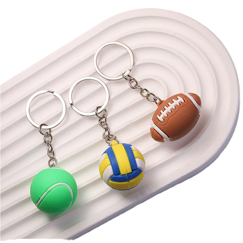Brown football, green tennis ball, and blue-and-yellow volleyball keychains.