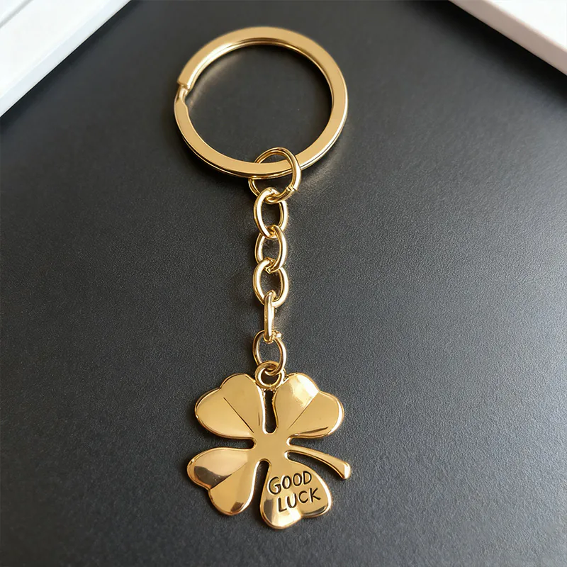 Gold-tone four-leaf clover keychain with GOOD LUCK lettering and a matching split ring.