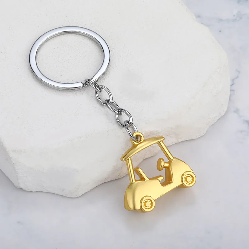 Gold-tone golf cart keychain with an open cabin and a silver-tone chain.