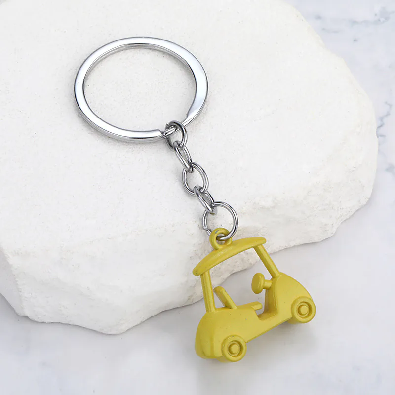 Yellow golf cart keychain with an open cabin, outlined wheels, and a silver-tone chain.
