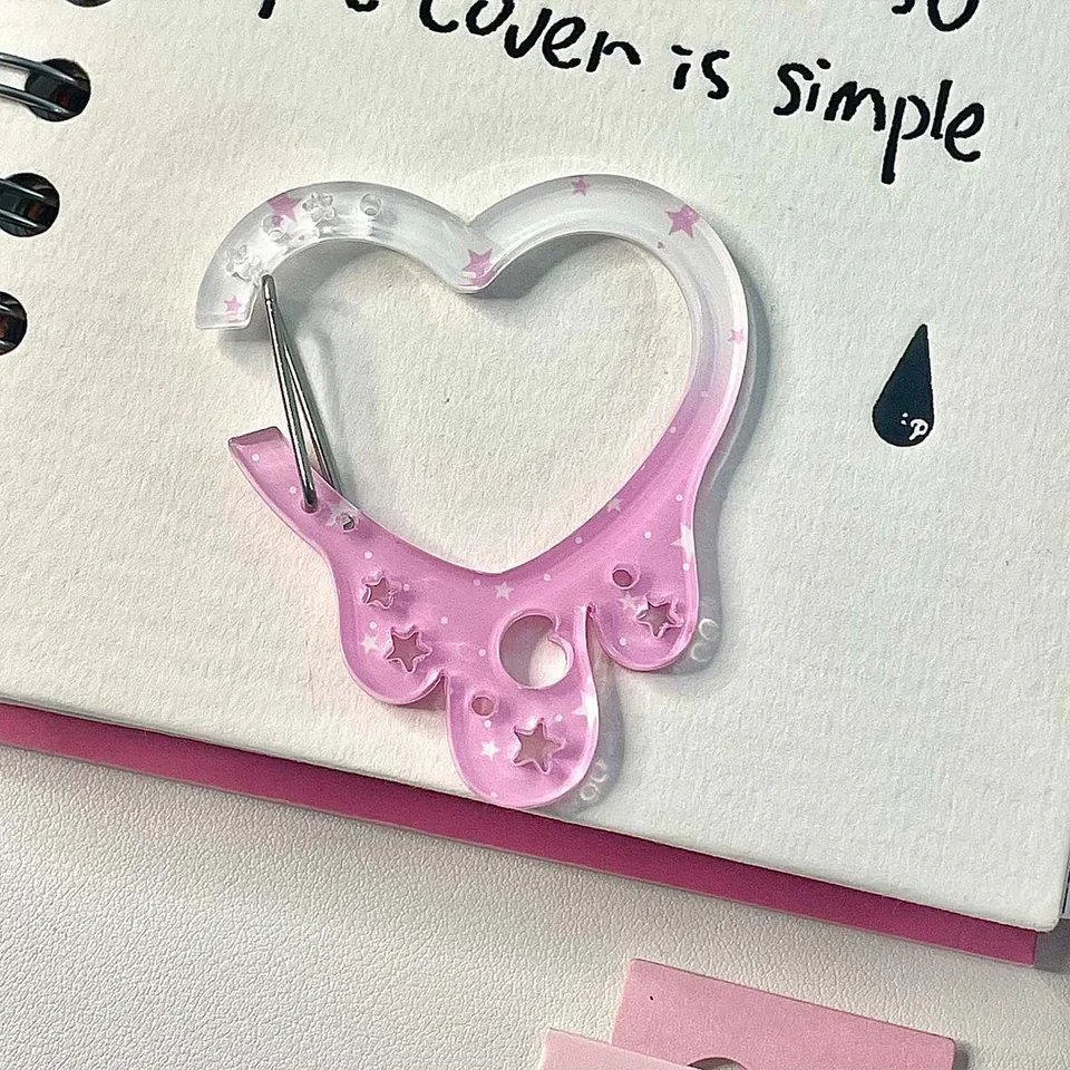 Clear and pink heart-shaped clip with star details and a silver-tone spring gate.