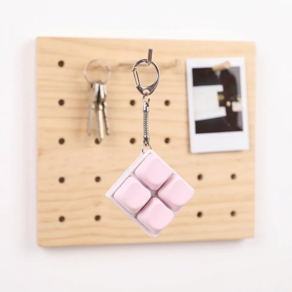 Pink four-key keyboard charm hanging from a silver-tone clasp.