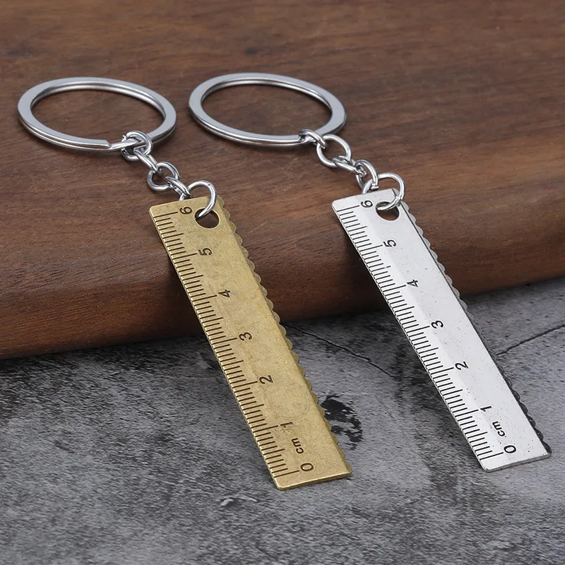 Brass-tone and silver-tone ruler keychains displayed side by side.