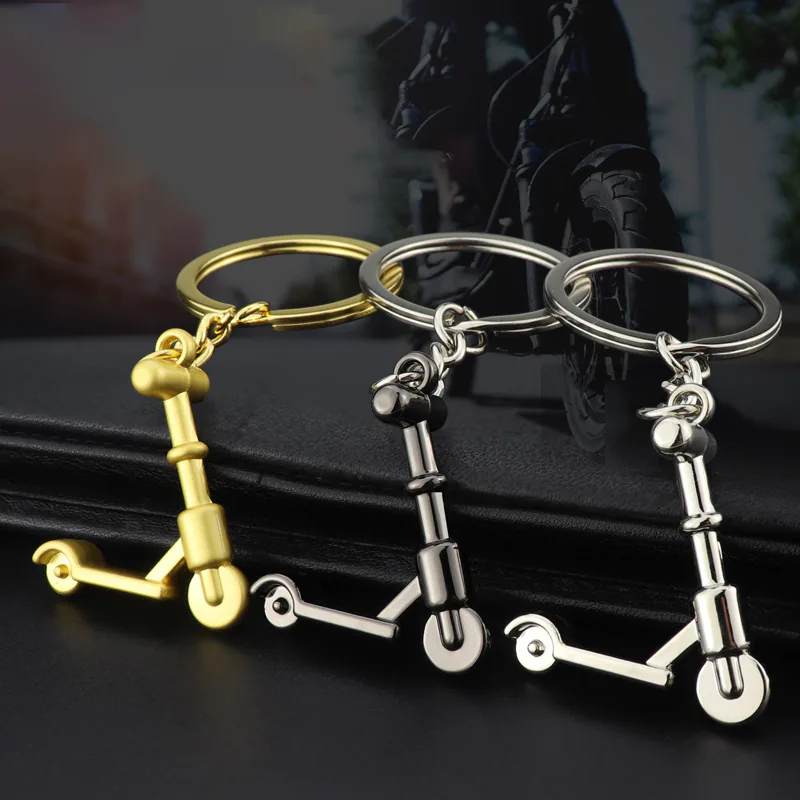 Three mini scooter keychains shown at an angle in gold, black, and silver tones.
