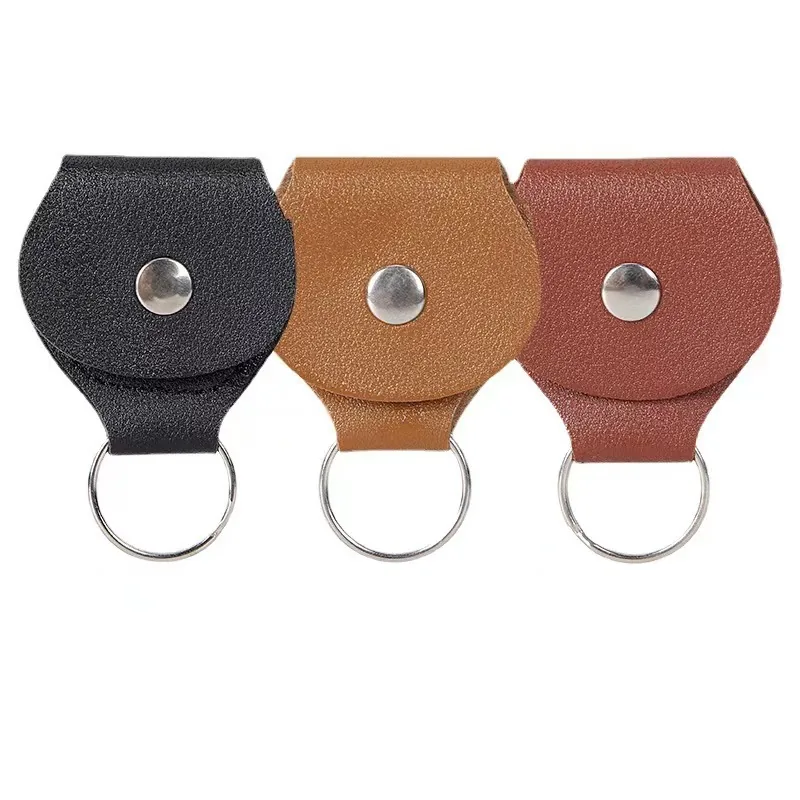 Black, tan, and reddish-brown mini pouch keychains with snap closures and split rings.