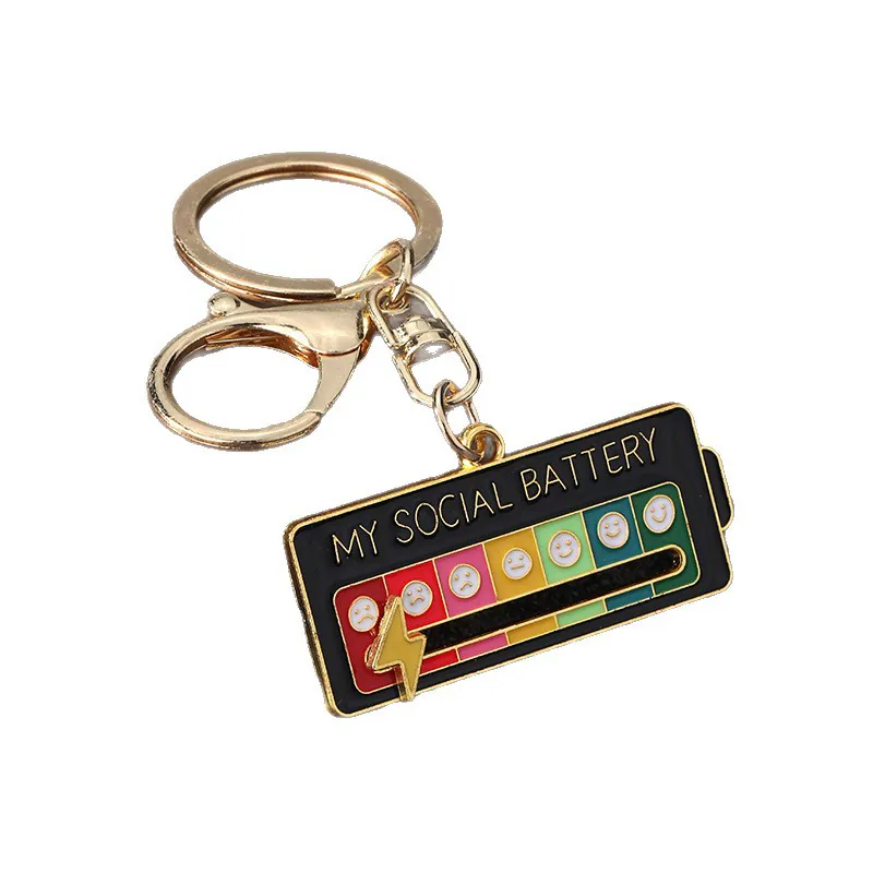 Black social battery keychain with multicolored face icons and a gold-tone lightning-bolt slider.