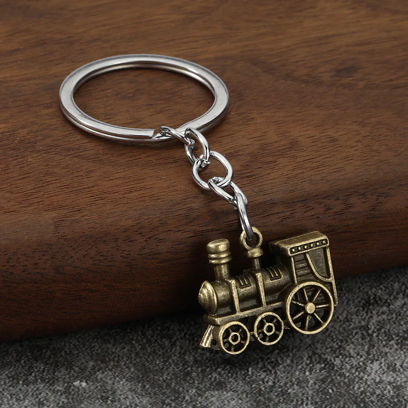 Antique brass-tone steam locomotive keychain with three wheels.