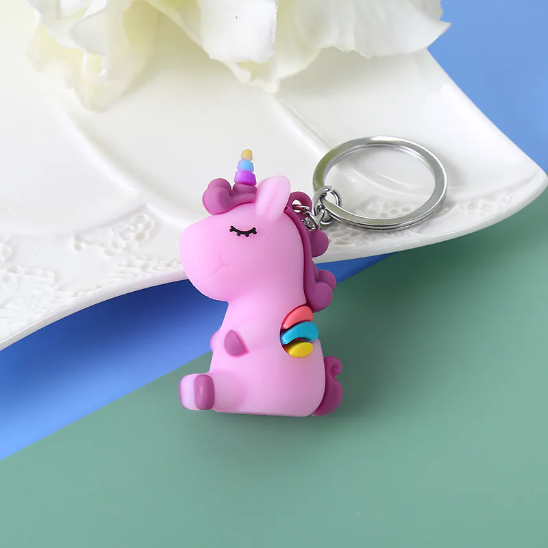 Purple unicorn keychain with a rainbow horn and tail.