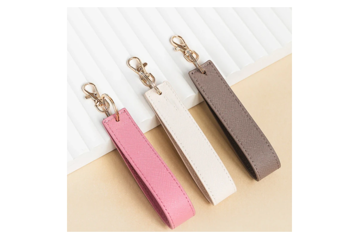 Pink, cream and taupe leather wristlet keychains with gold-tone clips.